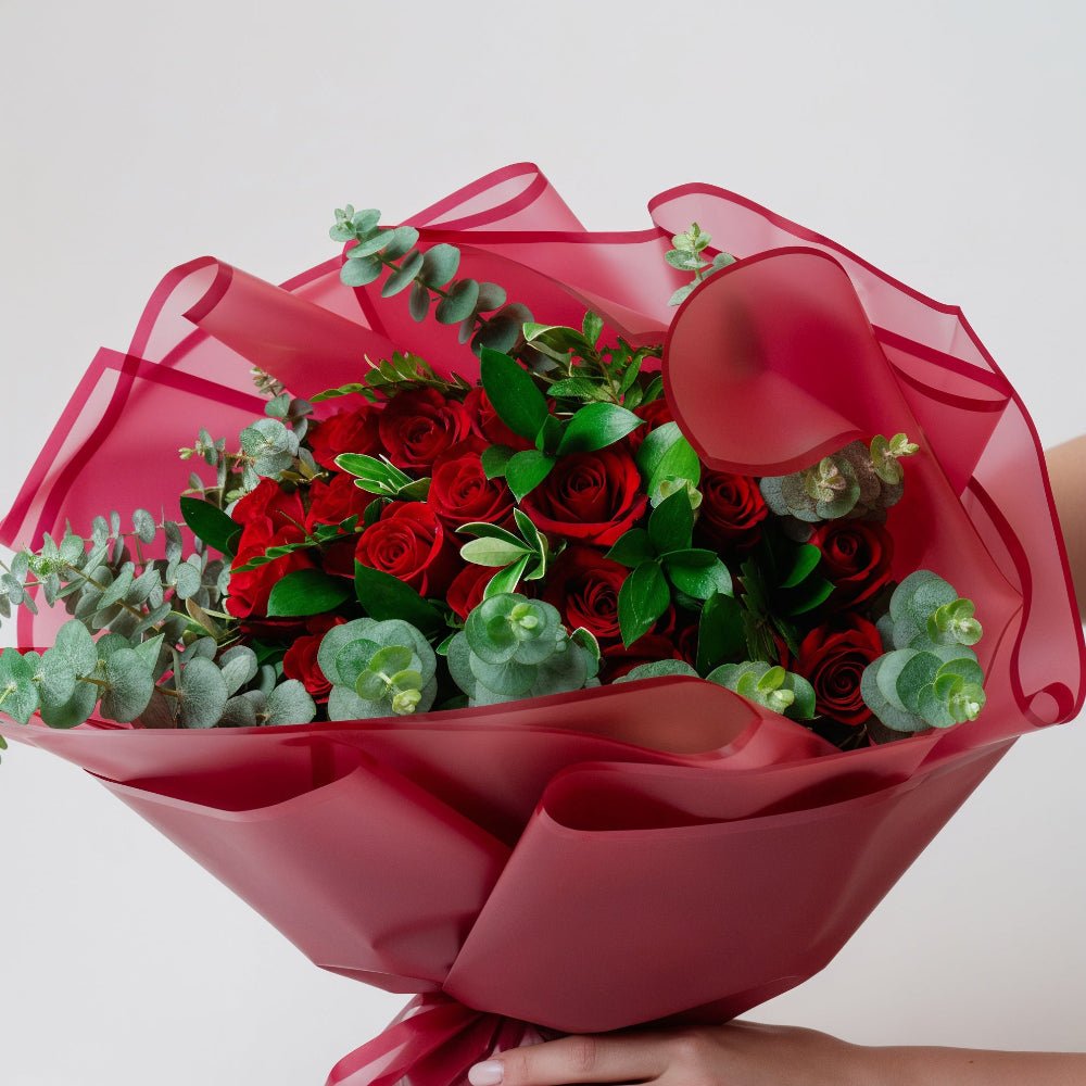 AMOROSSA - Bouquet 24 Ahava Premium - Ramo de rosas rojas con follaje verde envuelto en papel lila para Regalar Flores, Floristeria, Enviar Flores y Delivery.